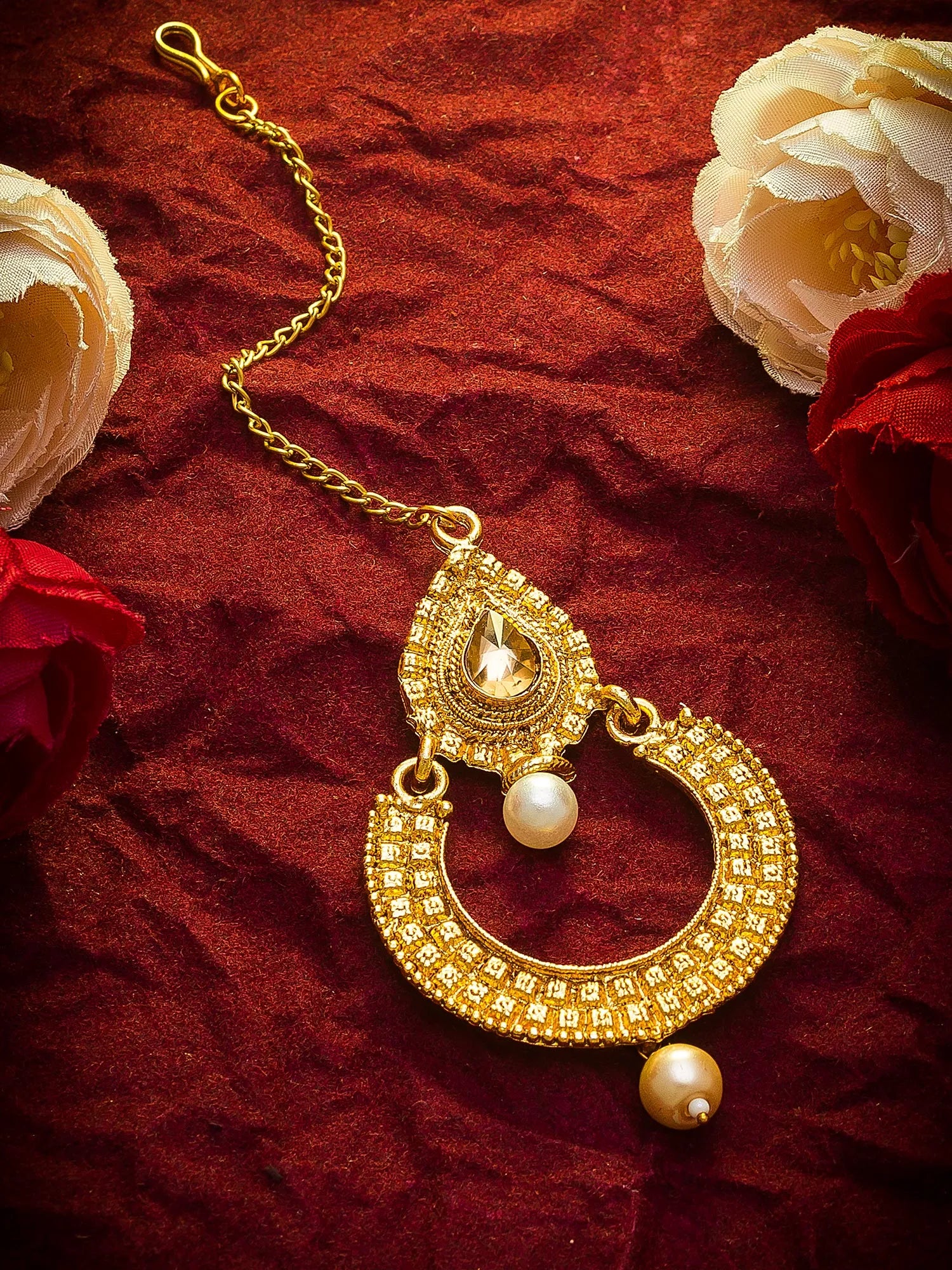 Gold necklace with a pearl pendant on a red fabric background
