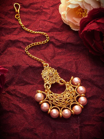 Gold necklace with pink pearls on a red fabric background