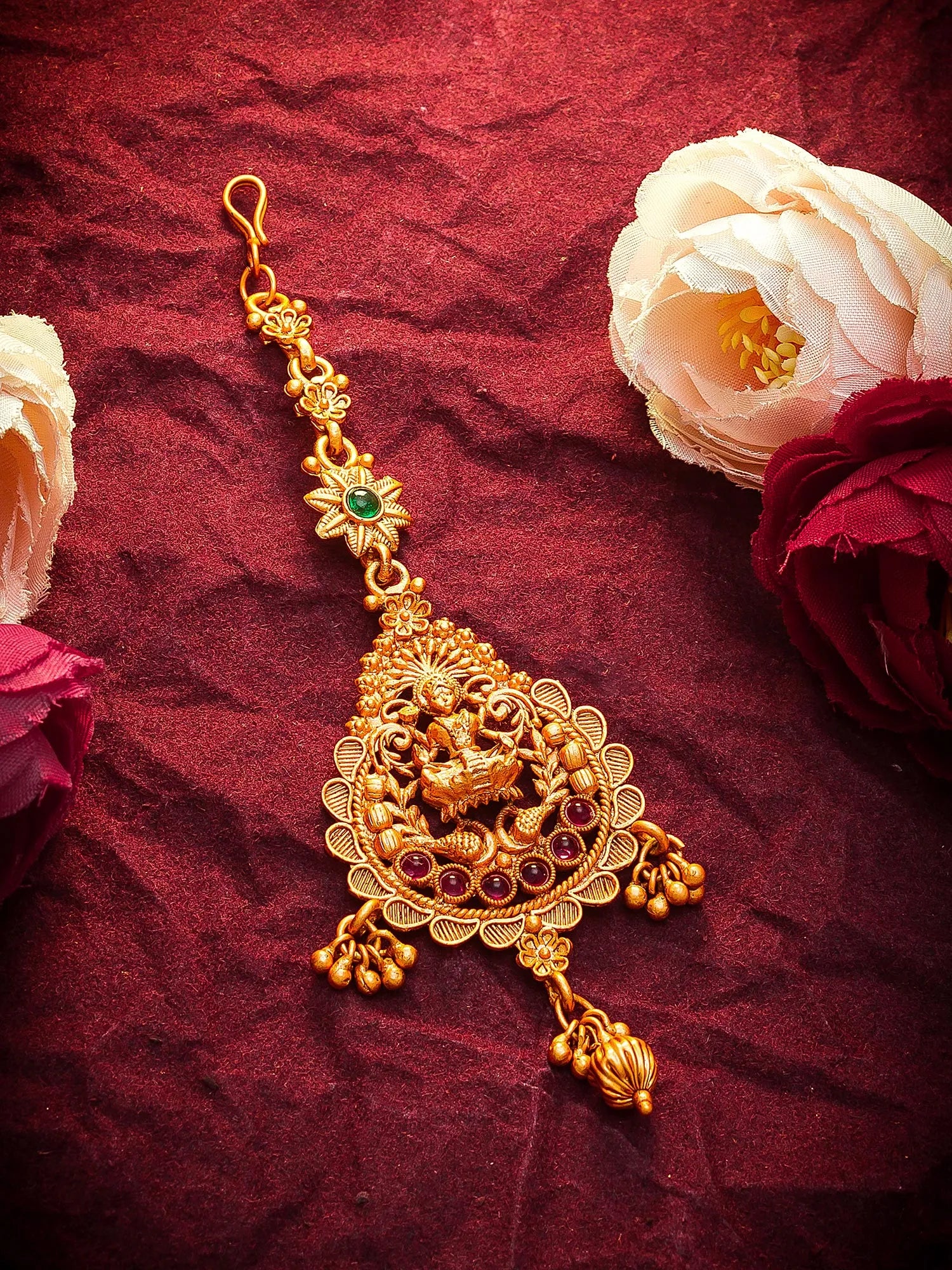 Gold necklace with floral decorations on a red fabric background