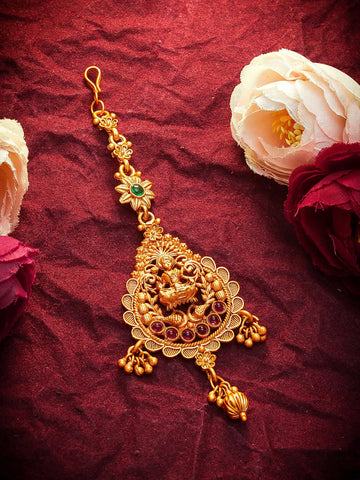 Gold necklace with floral decorations on a red fabric background