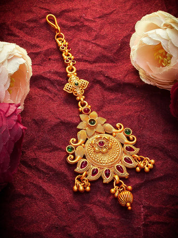 Gold decorative hanging with gemstones on a red fabric background