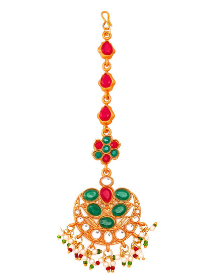 Decorative gold pendant with red and green gemstones on a white background