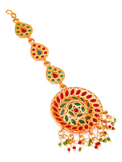 Decorative gold bracelet with red and green stones on a white background