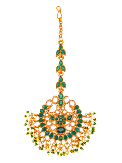 Decorative gold and green pendant on a white background