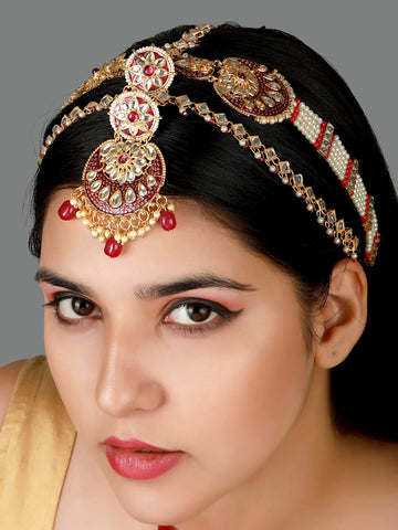 Woman wearing a decorative headpiece with gold and red elements on a dark background