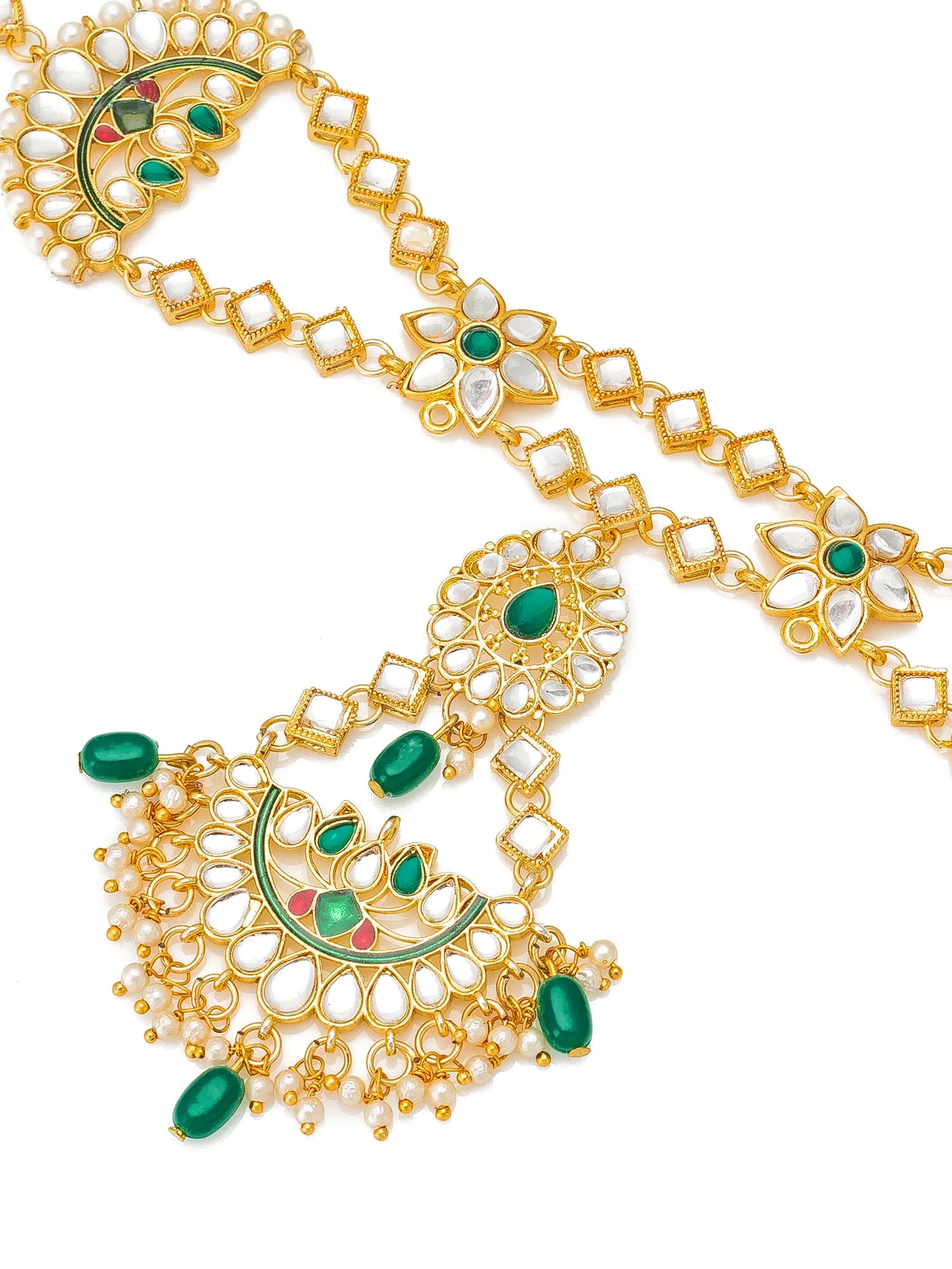 Gold-plated Indian bridal jewelry set featuring a maang tikka with a crescent moon and peacock motif, embellished with green stones, white faux pearls, and small red accents, shown on a plain white background.