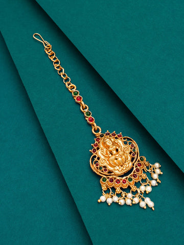 Gold jewelry piece with pearls and gemstones on a green background