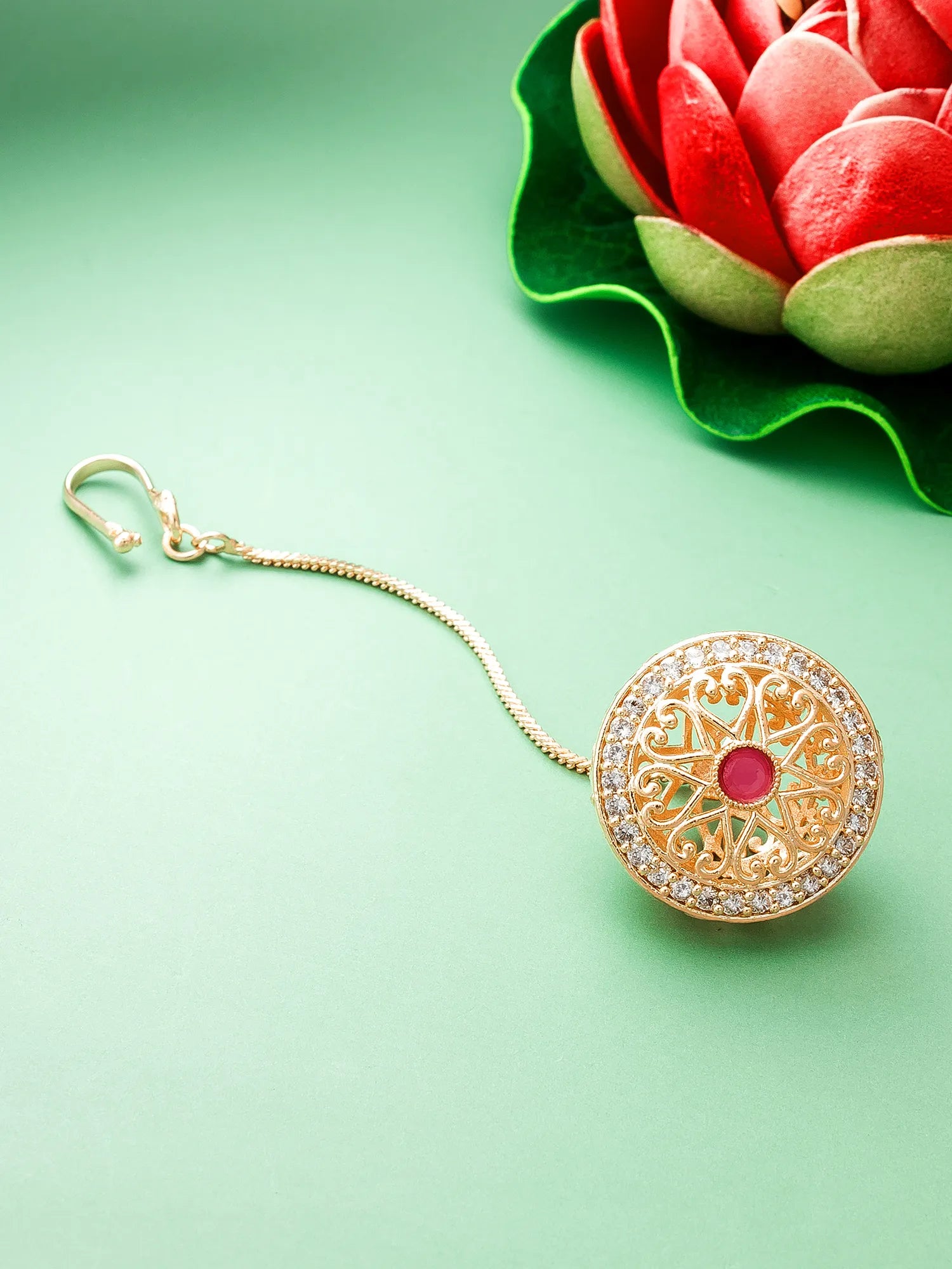Decorative keychain with intricate design on a green background