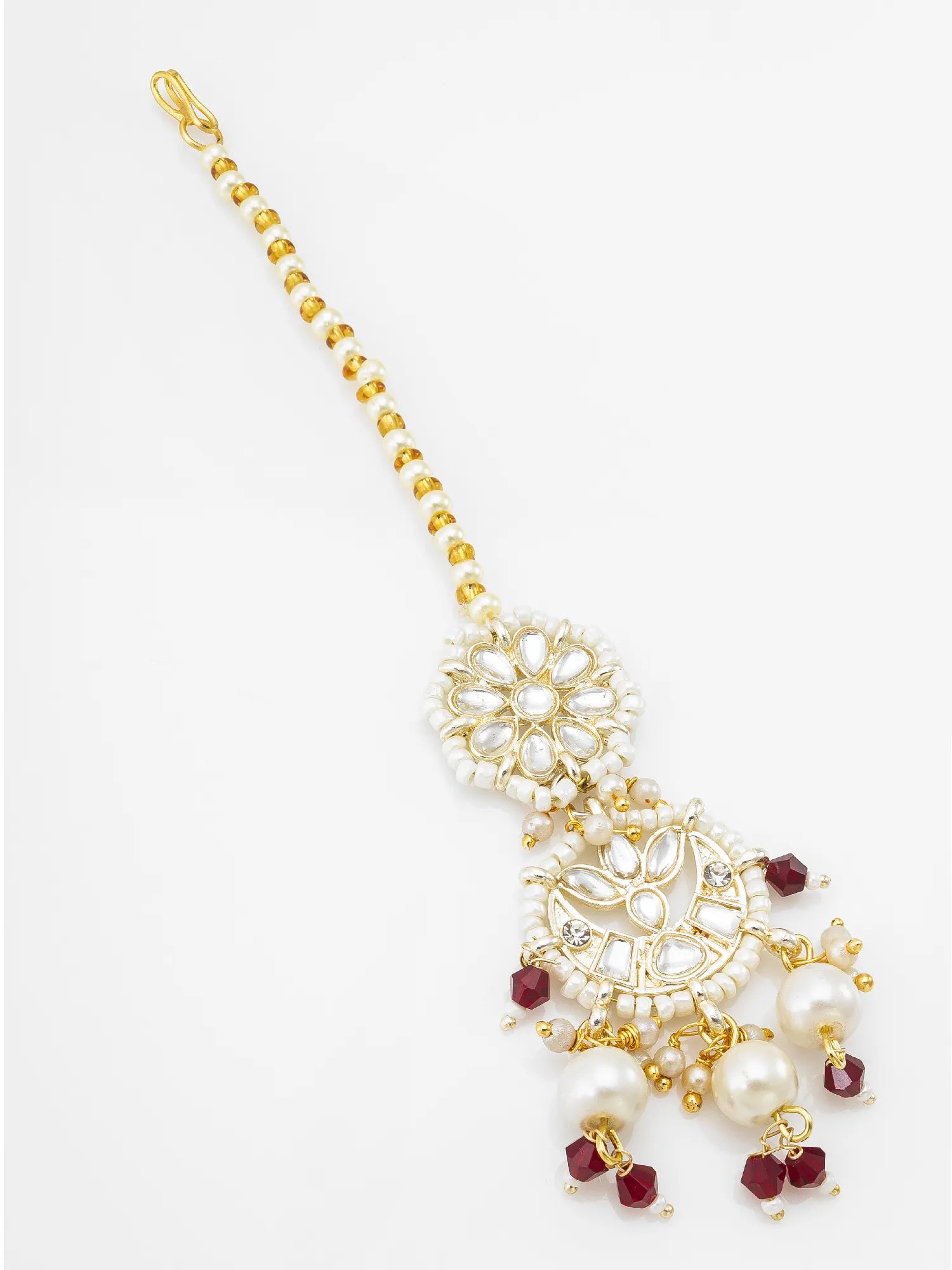 Gold-plated Indian style maang tikka with white faux pearls and small red faceted gemstone accents, shown on a plain white background.