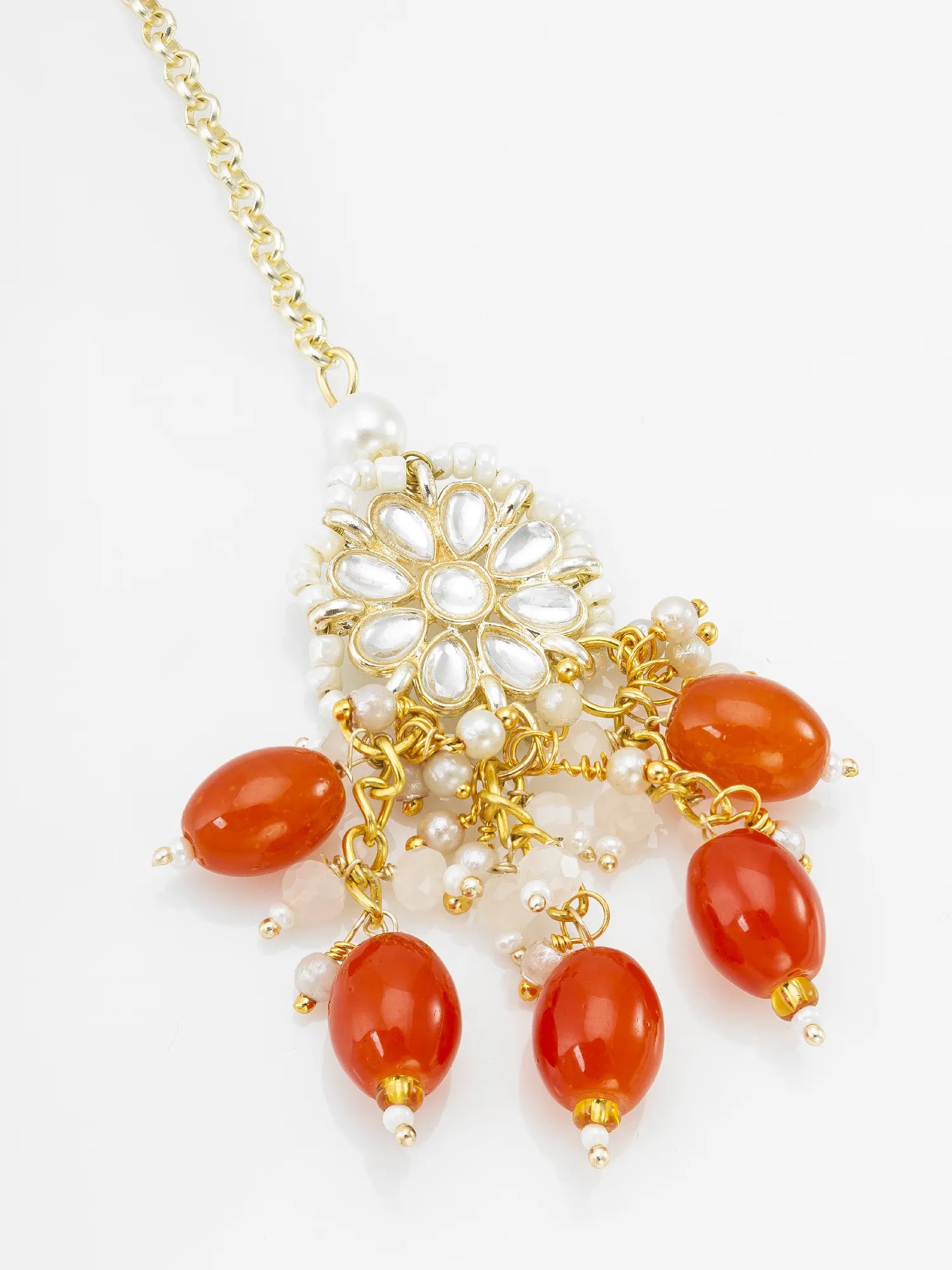 Necklace with gold chain, red beads, and white pearls on a white background