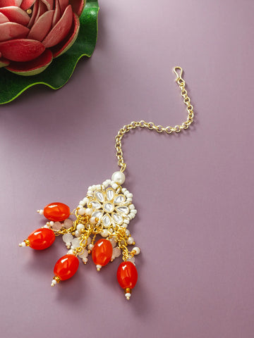 Jewelry with red beads and gold chain on a purple background