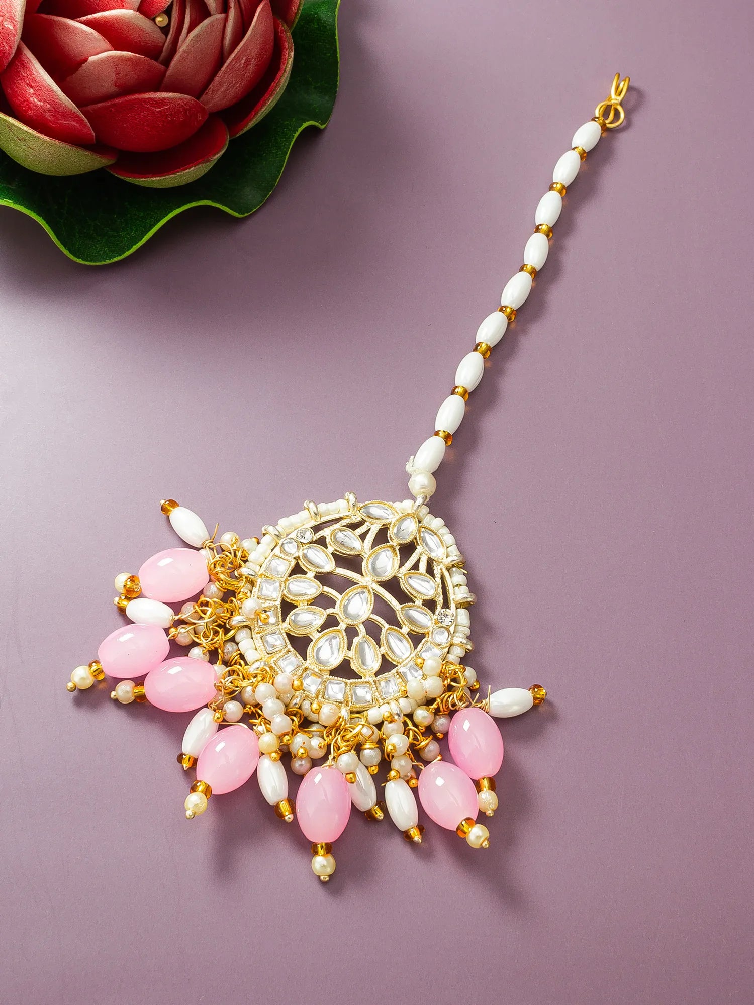 Decorative necklace with pink and white beads on a purple background
