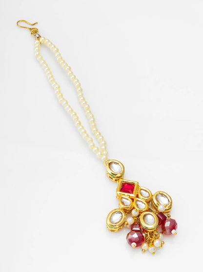 Decorative necklace with gold chain, red stones, and pearls on a white background