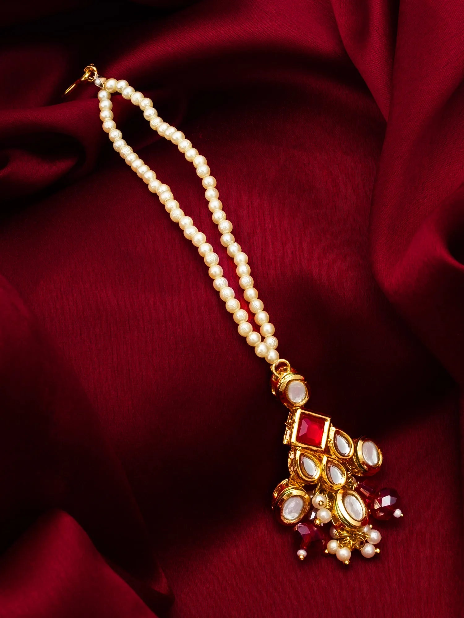 Pearl necklace with a decorative pendant on a red fabric background