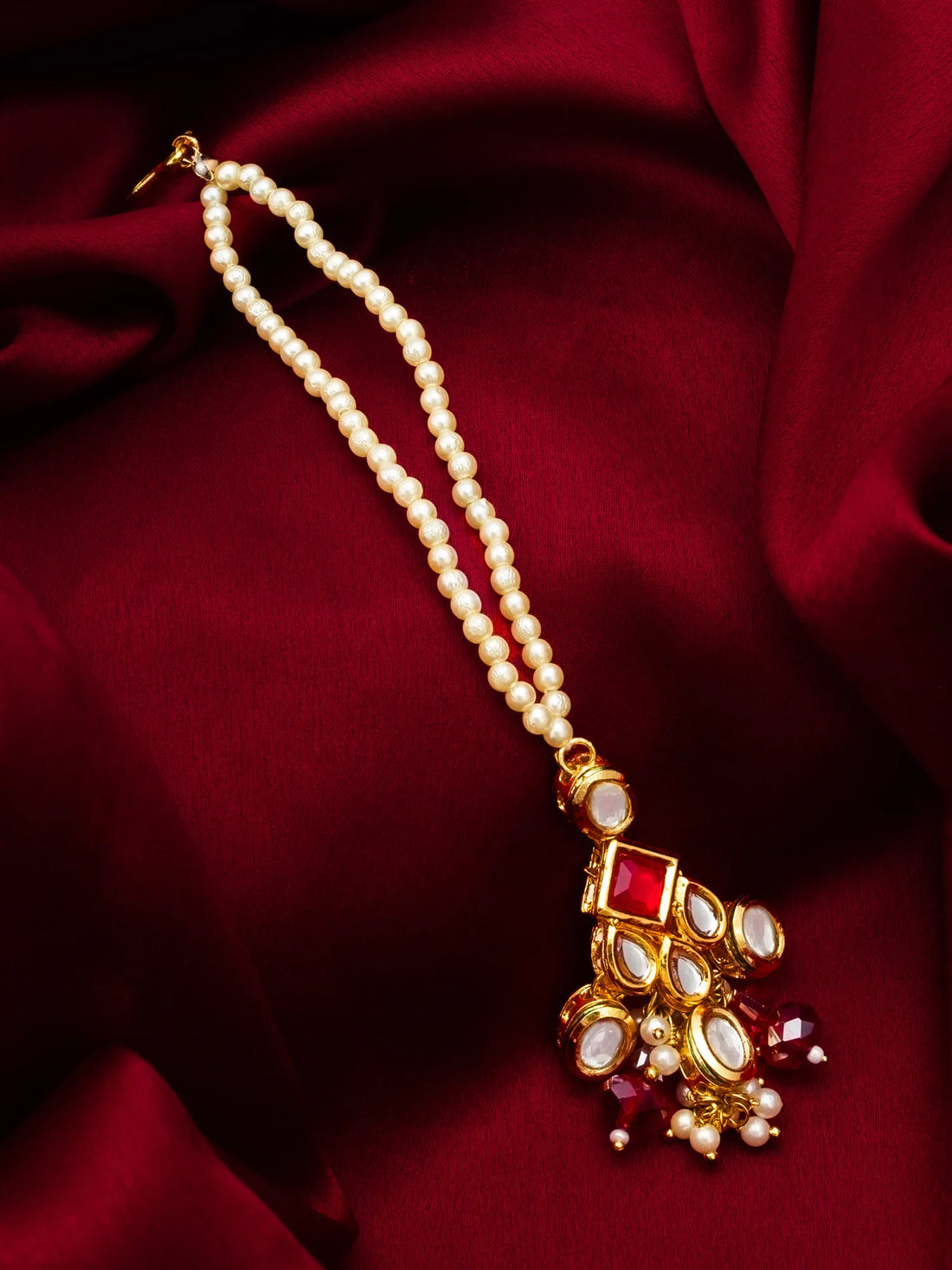 Pearl necklace with a decorative pendant on a red fabric background