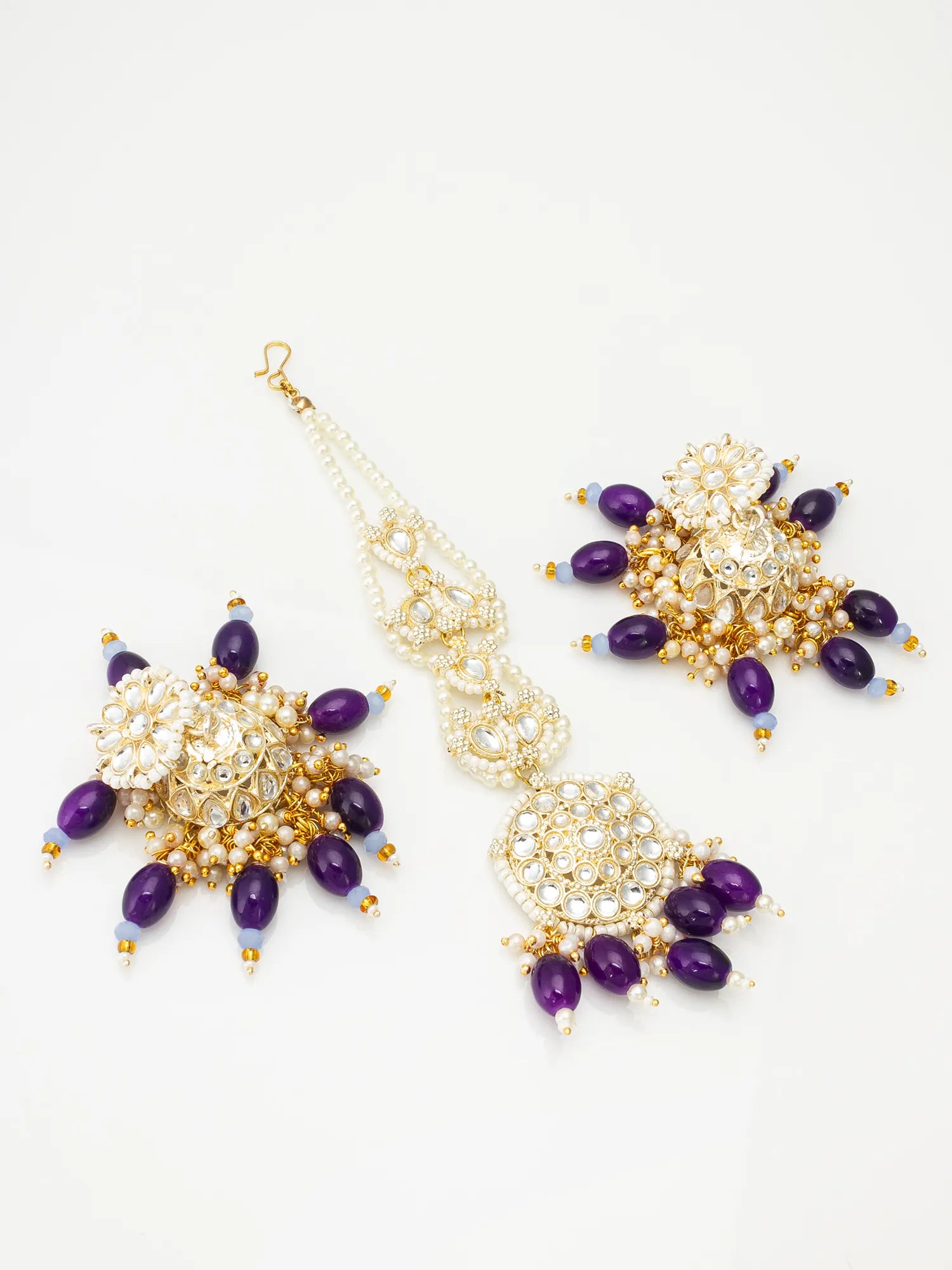 Pair of gold and purple beaded earrings on a white background