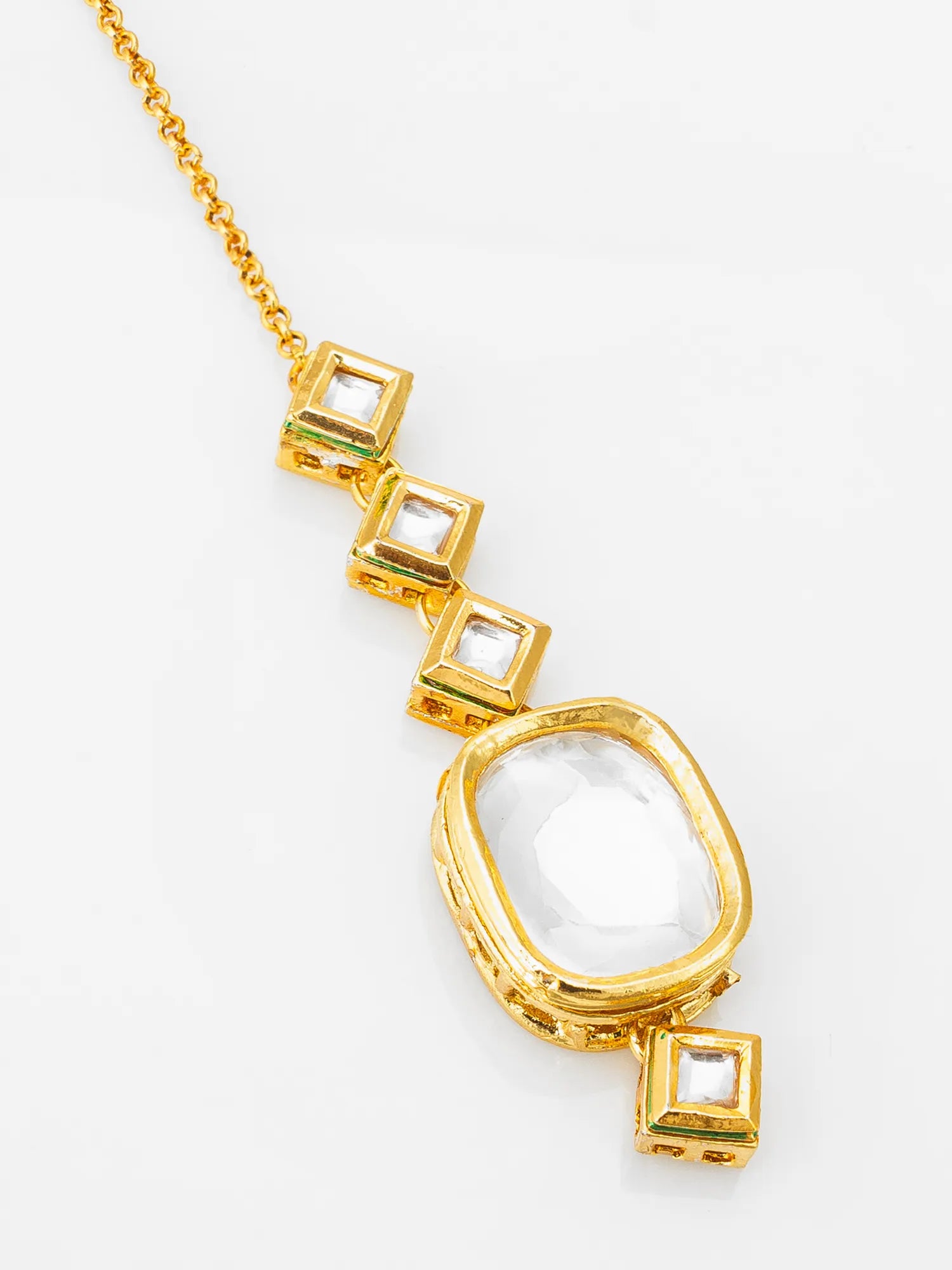 Gold necklace with geometric pendant on a white background