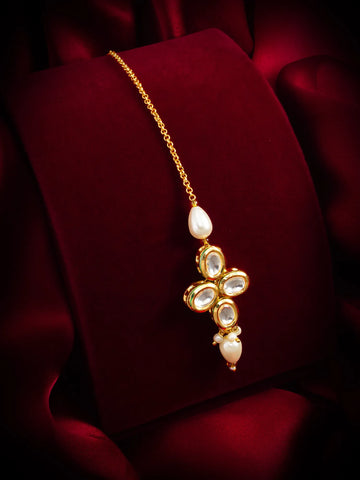 Gold necklace with a floral pendant on a red fabric background