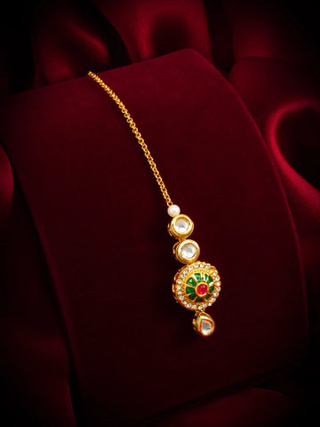 Gold necklace with a decorative pendant on a red fabric background