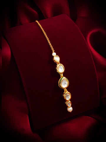 Gold bracelet with pearls on a red fabric background