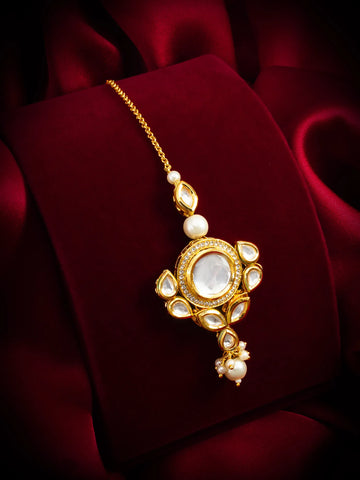 Gold necklace with a pendant on a red fabric background