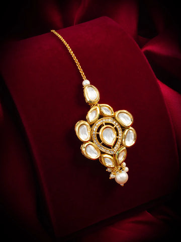 Decorative gold necklace with pearls on a red fabric background