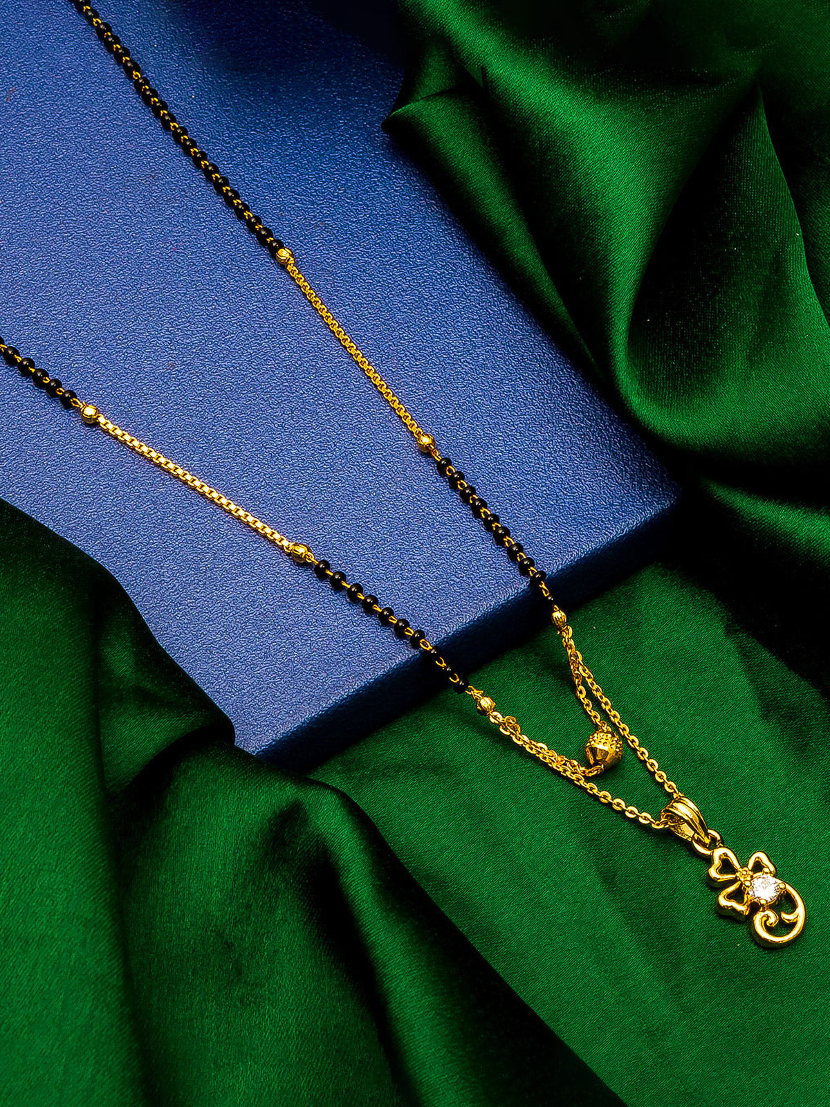 Aadita Gold-Toned Bow and Scroll Mangalsutra with Single Stone Pendant and Black Beads Chain