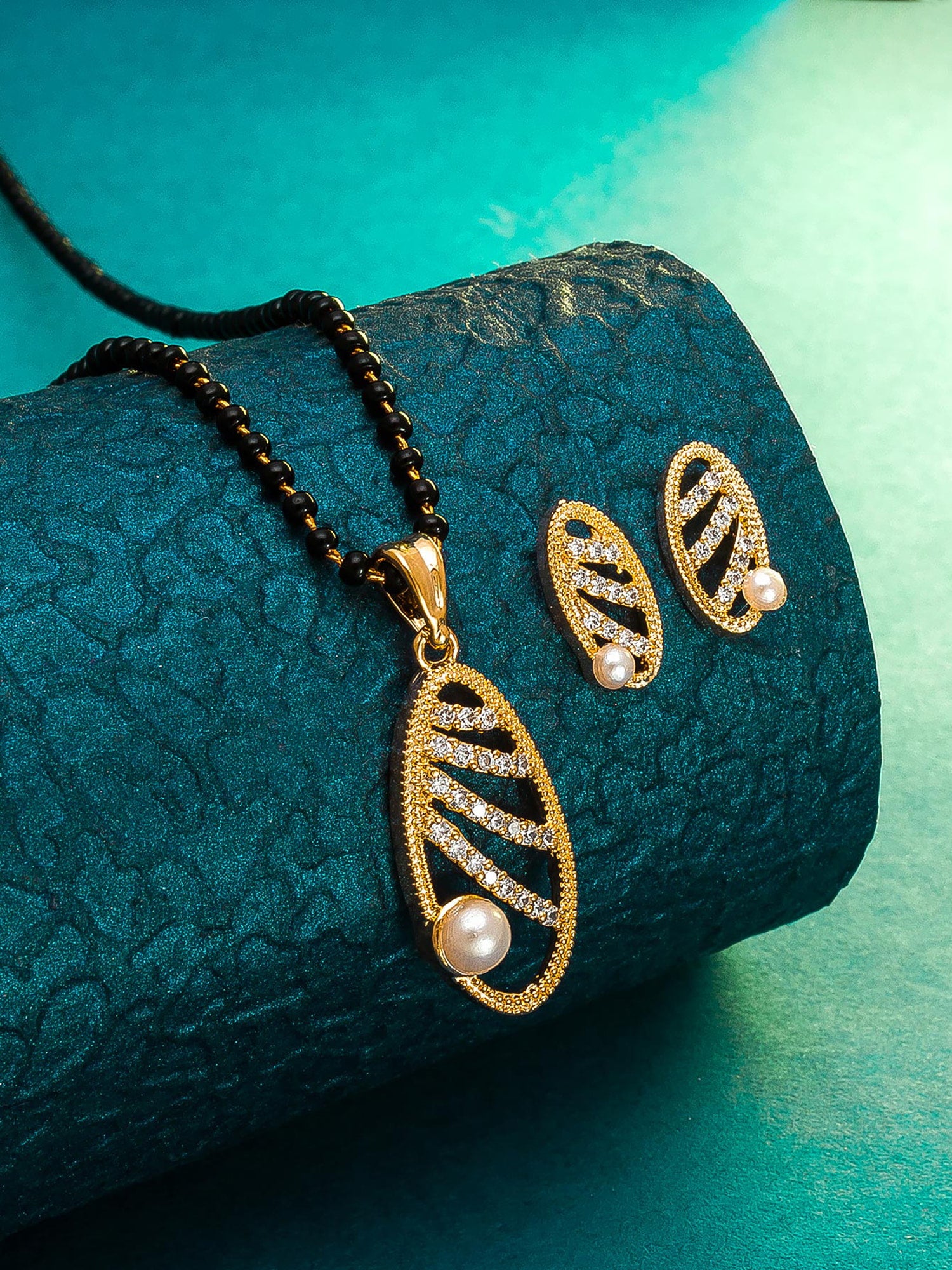 Aadita Festive Wear Gold-Toned Oval Cutwork and Pearl Mangalsutra Set with Black Beads Chain and Matching Earrings