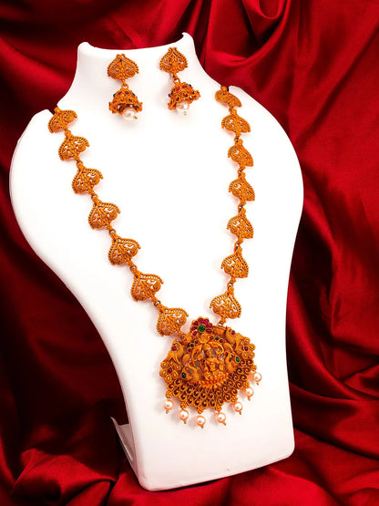 Ornate necklace and earrings on a white stand with a red fabric background