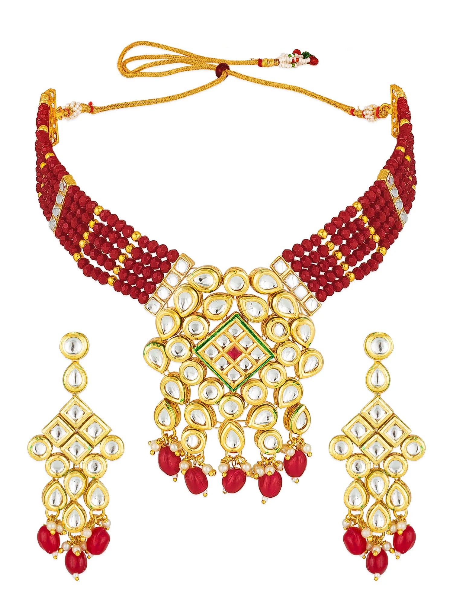 A traditional Indian gold-plated necklace and matching earrings set. The necklace features a wide collar of deep red beads, a central gold-plated pendant decorated with white stones, a green and red inlay, and dangling red bead drops.