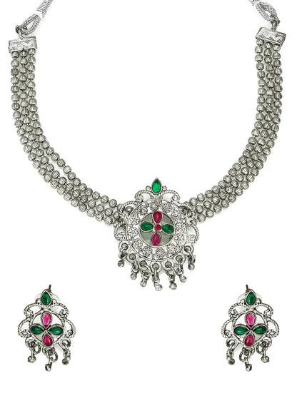Silver necklace with green and red stones on a white background