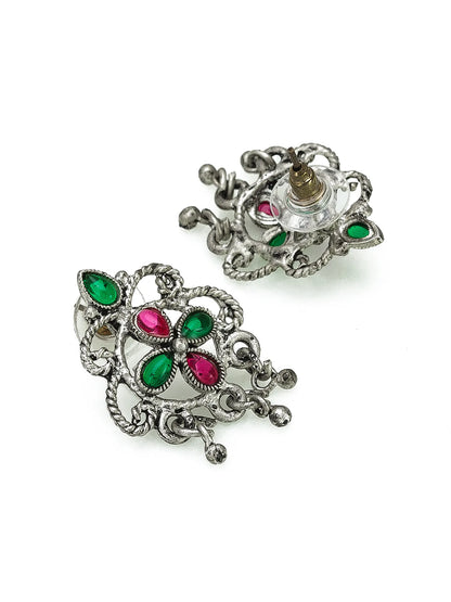 Ornate silver earrings with green and red gemstones on a white background