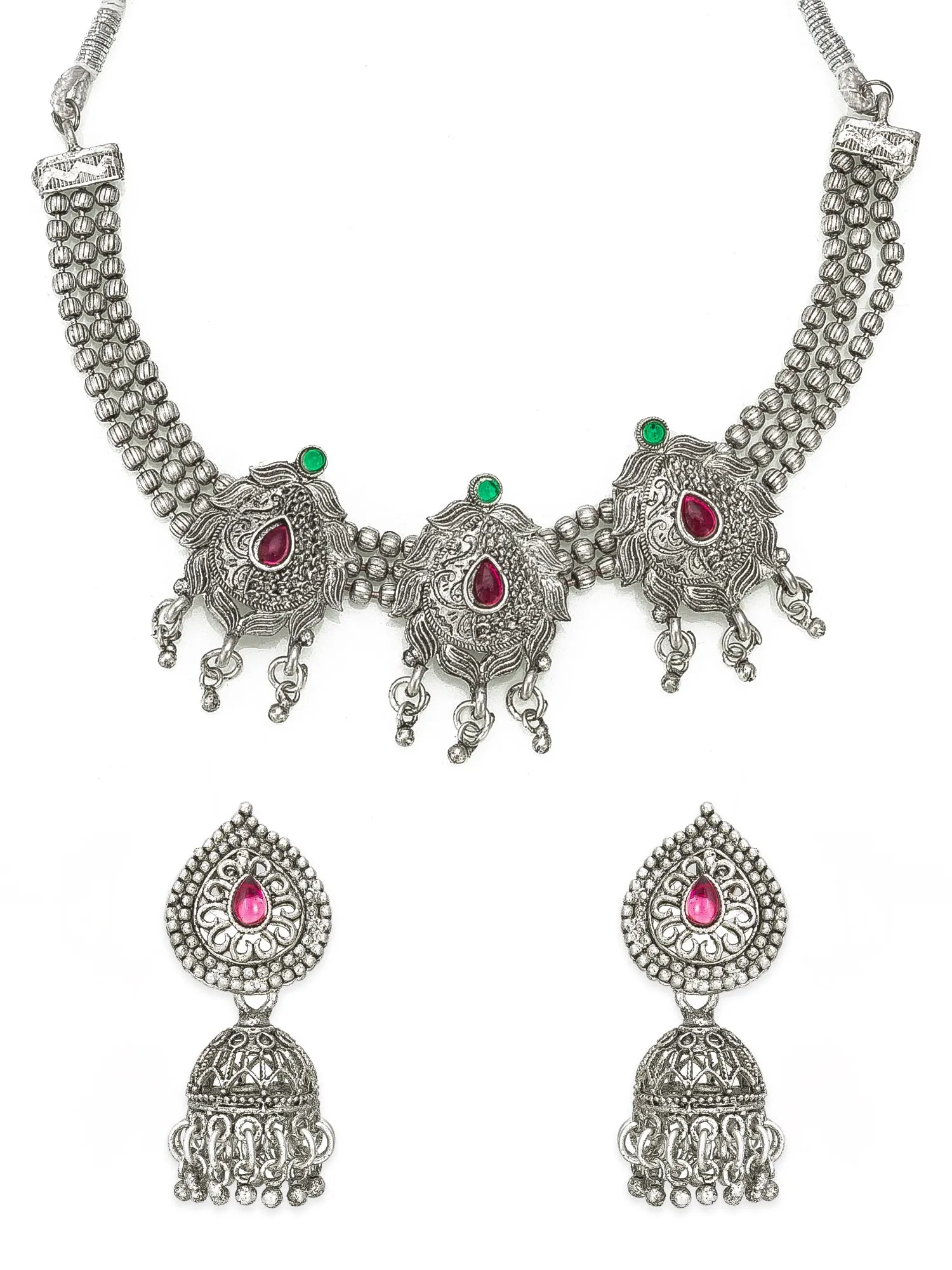 Silver-toned traditional Indian jewelry set featuring a statement necklace and matching drop earrings with pink teardrop stones and small green accent stones, displayed on a white background.