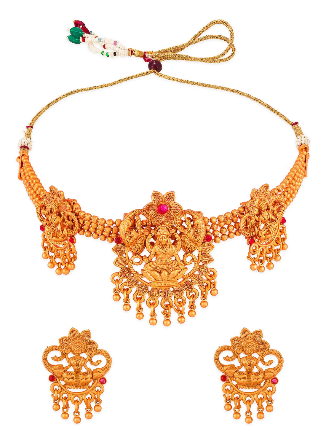 An ornate gold-toned traditional jewelry set displayed on draped dark green satin fabric, including a necklace, earrings, and matching pendant pieces with floral and filigree details.
