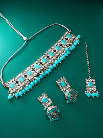 Jewelry set with necklace, earrings, and tikka on a green background
