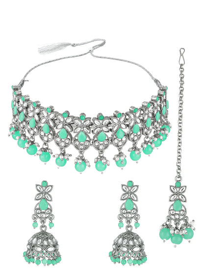 Silver-toned traditional Indian jewelry set featuring a choker necklace, matching drop earrings, and a maang tikka, embellished with mint green teardrop and round stones on a white background.