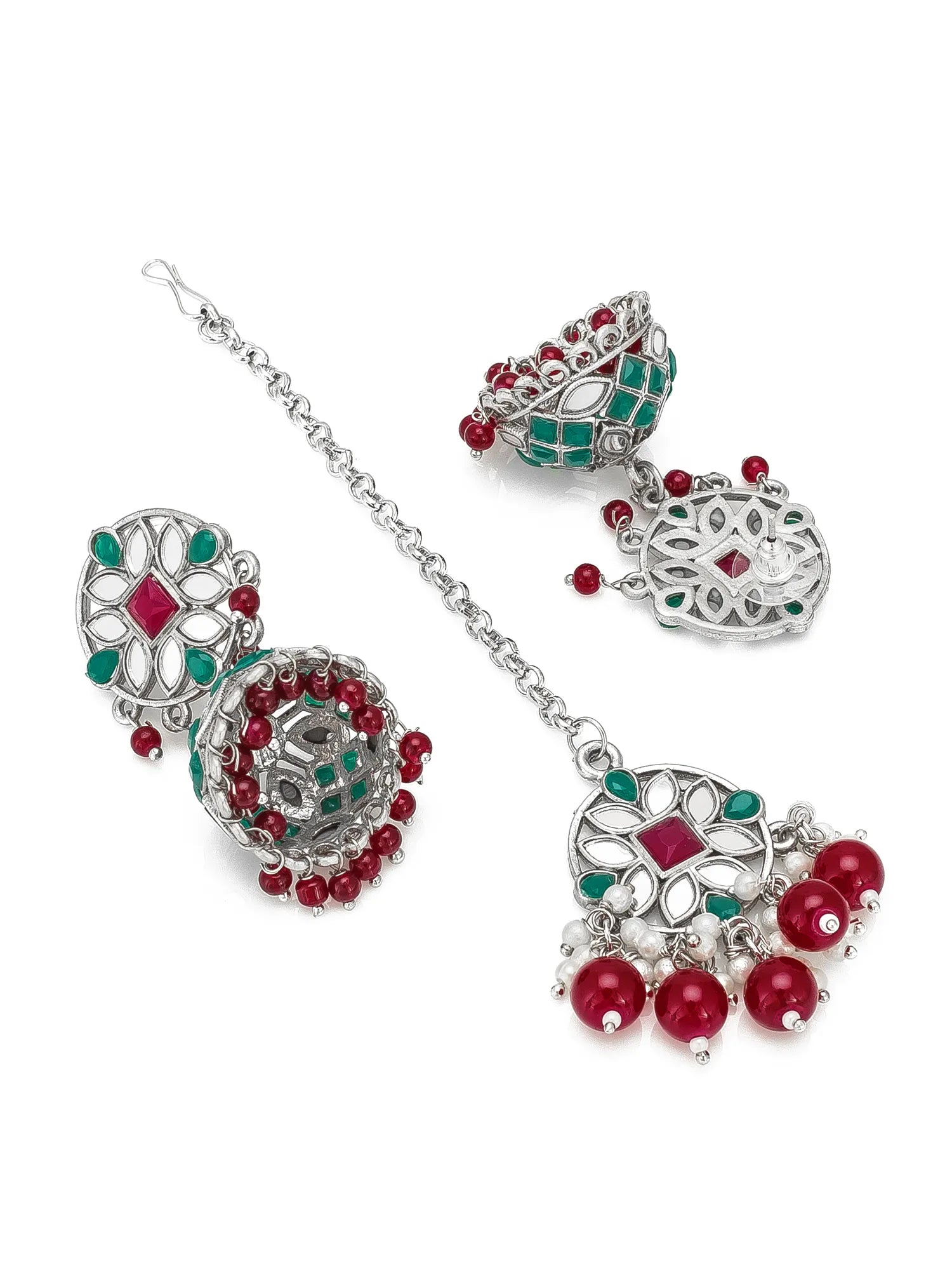 Silver-toned traditional Indian jewelry set featuring a chain with three matching jhumka earrings, decorated with red and green stones and bead drops, on a white background.