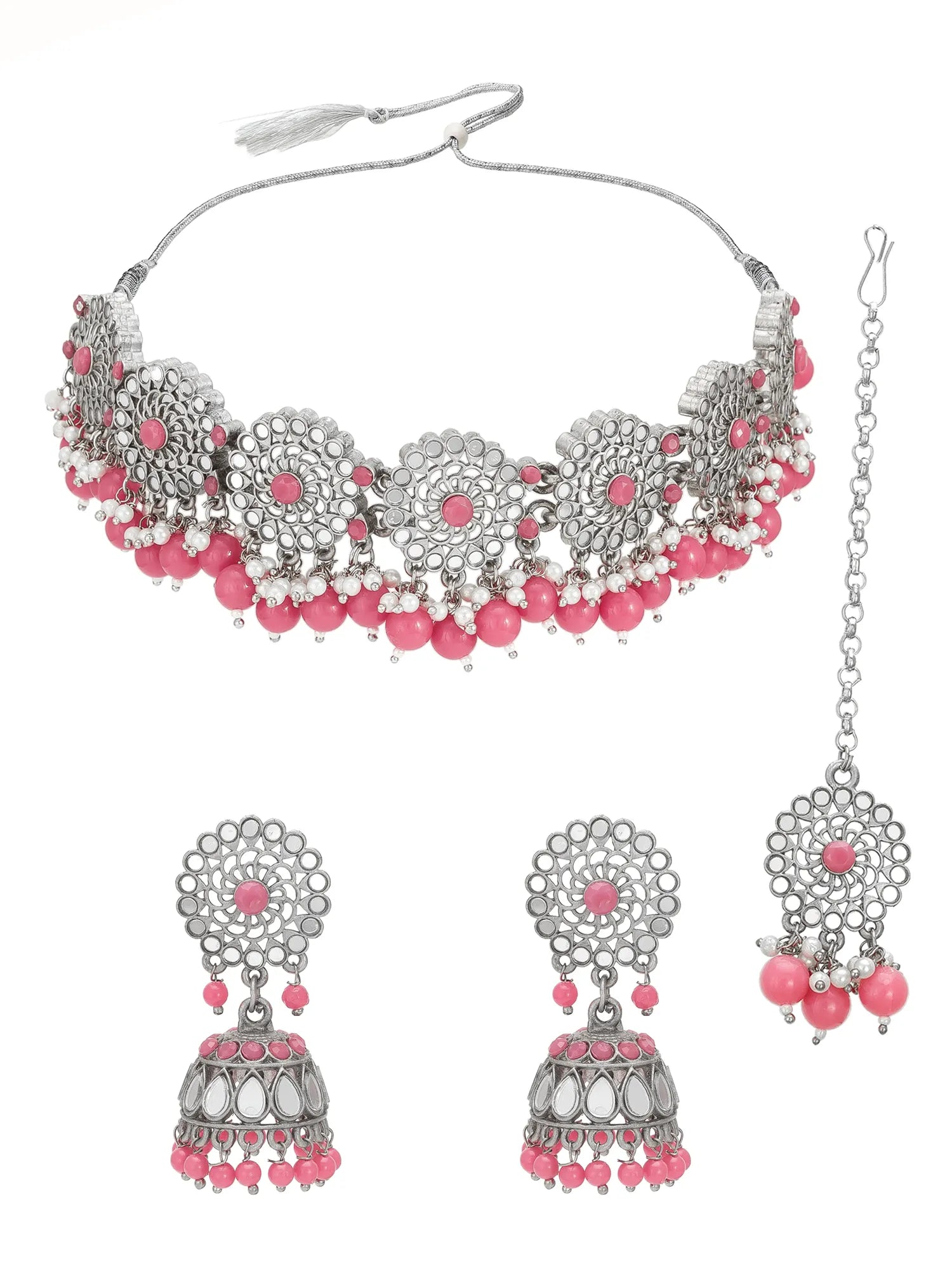 Silver-toned traditional Indian jewelry set featuring a choker necklace, matching jhumka earrings, and a maang tikka, decorated with silver filigree, pink beads, and pink stone centers, shown on a white background.