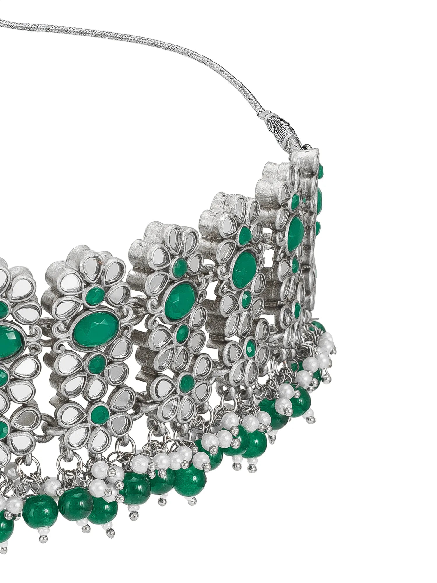 A close-up of a silver-toned statement choker necklace featuring green gemstone accents and dangling bead details, set against a plain white background.