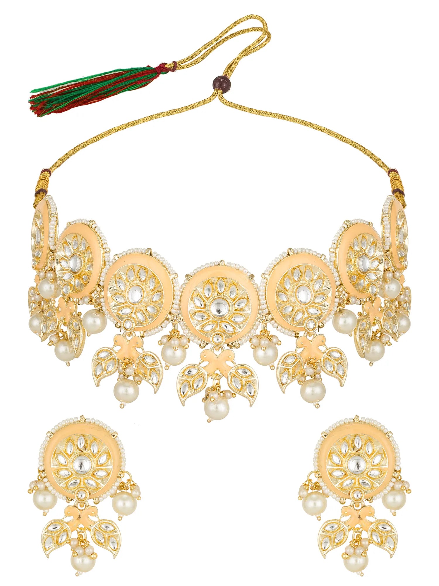 Gold-toned traditional Indian jewelry set featuring a choker necklace with a tassel, matching drop earrings, and white faux pearls on a plain white background.