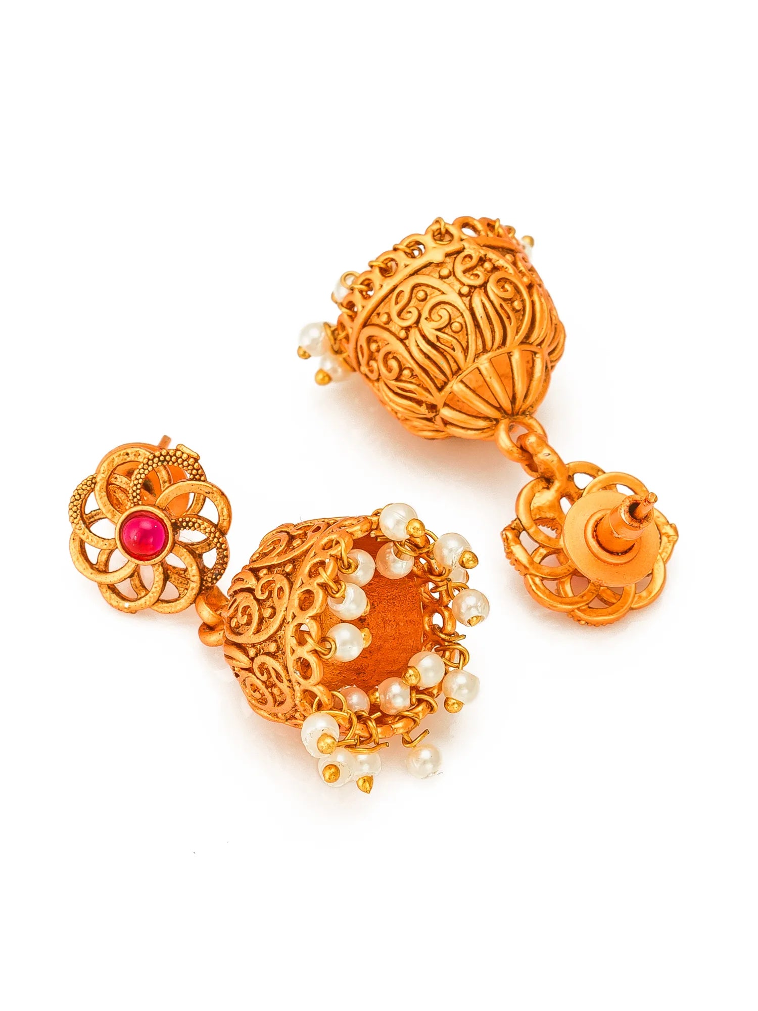 A pair of traditional Indian gold-toned earrings with intricate filigree work, white pearl bead accents, and a small red gemstone on one earring, displayed on a clean white background.
