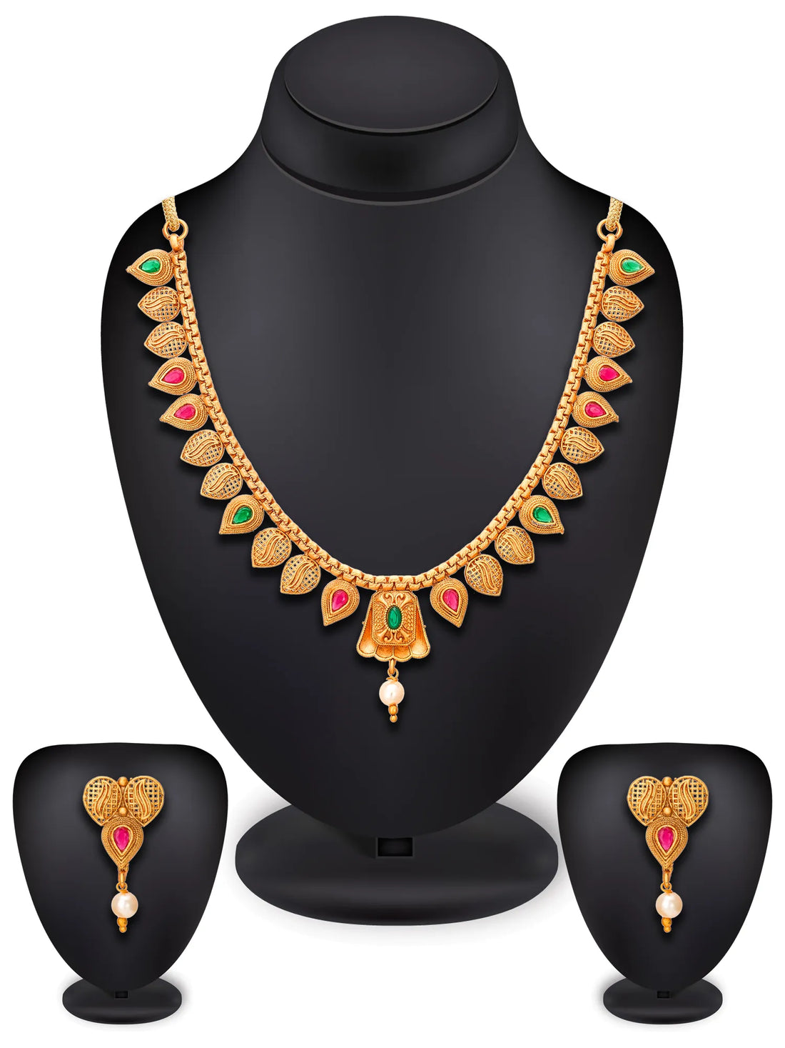 Gold-toned traditional necklace and matching drop earrings with leaf-shaped motifs, red and green stone accents, and pearl-like dangling beads, arranged on a dark surface with red fabric in the background.