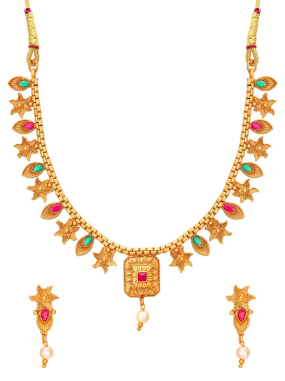 Gold-plated traditional Indian jewelry set featuring a necklace and matching earrings, embellished with red gemstones, green stones, and white pearl drops on a plain white background.