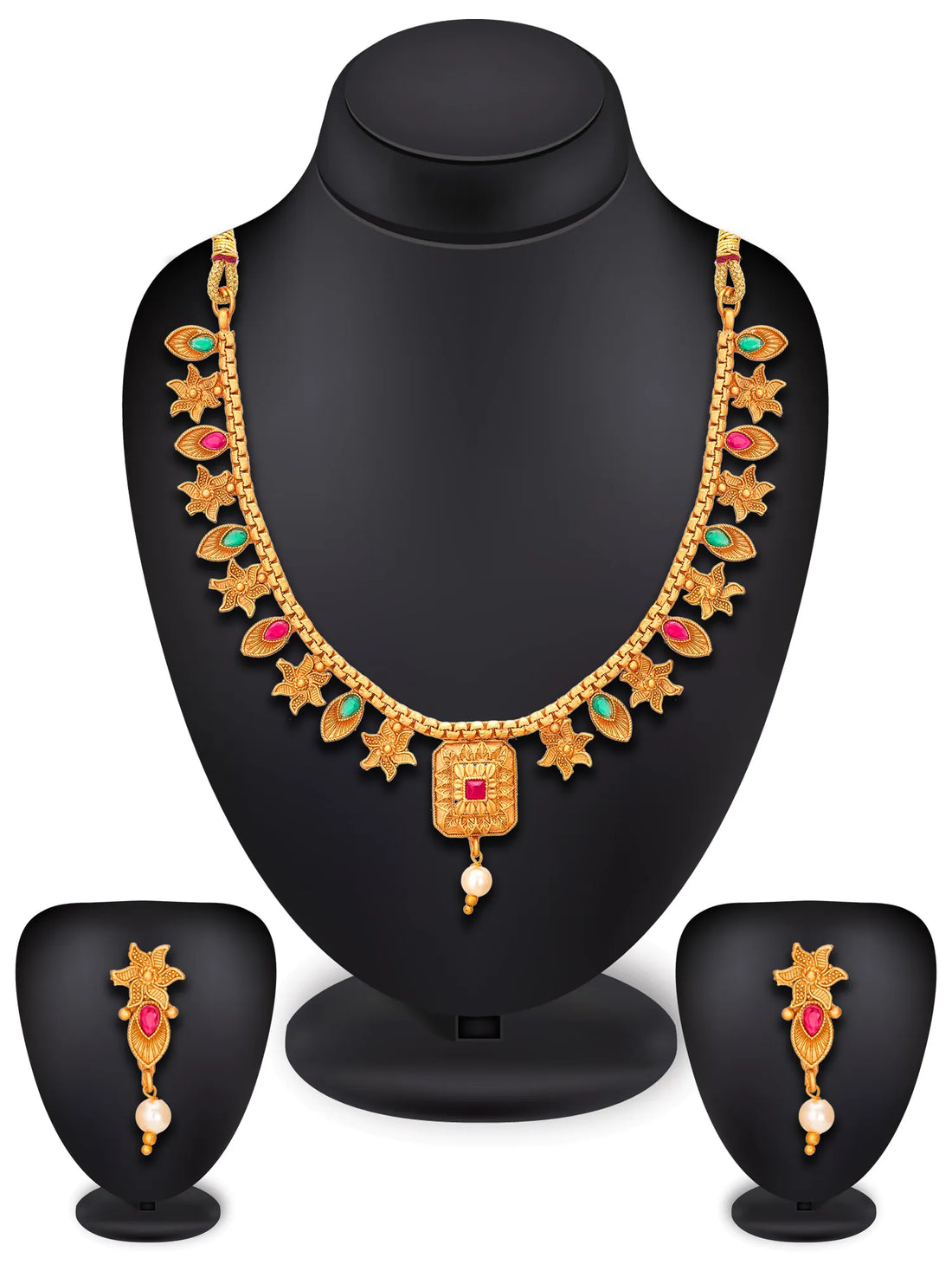 Gold-toned traditional necklace and matching drop earrings with red and green stone accents and pearl details, displayed on a dark surface with red fabric in the background.
