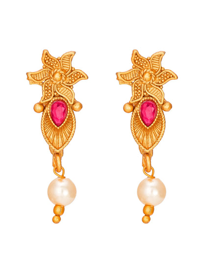 A pair of gold-toned traditional Indian dangle earrings featuring a floral motif, a pink teardrop gemstone, and a dangling white pearl bead.