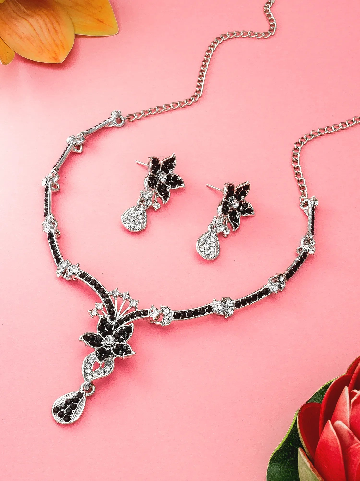 Jewelry set with necklace and earrings on a pink background