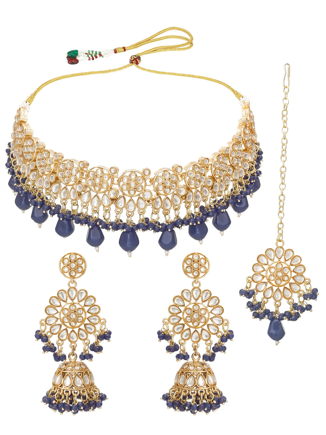 Gold and white stone jewelry set with navy blue bead accents, including a statement necklace, matching earrings, and a chain, arranged on a coral background.