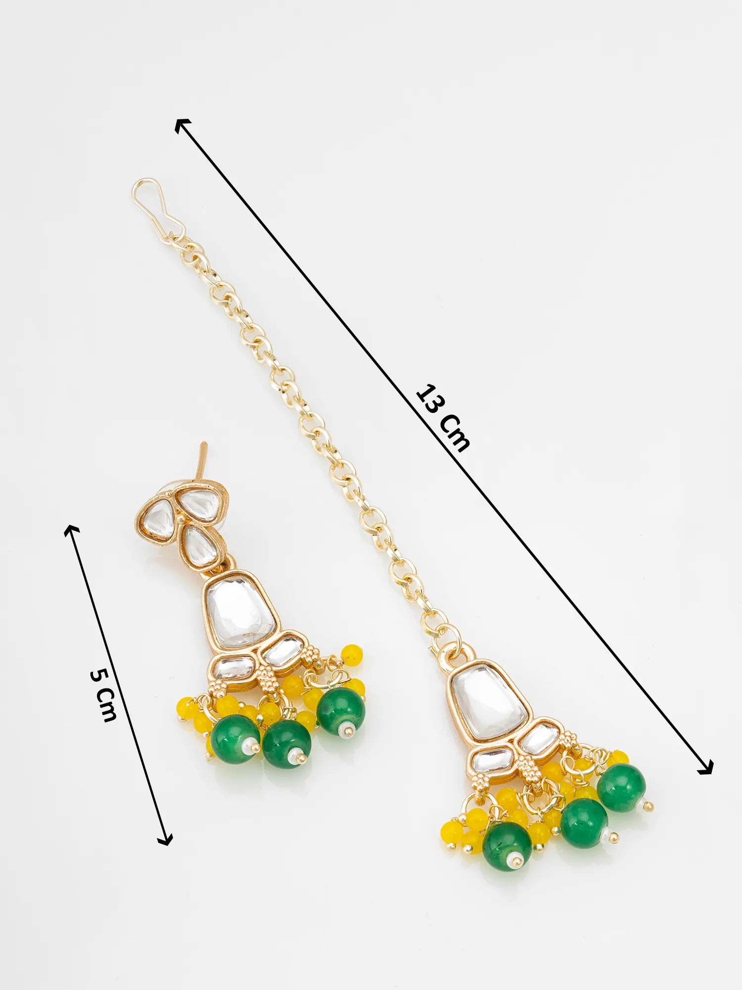 Gold-toned jhumka earrings with white stone accents and green and yellow bead clusters, shown on a light gray background with measurement lines indicating 13 cm length and 5 cm drop.