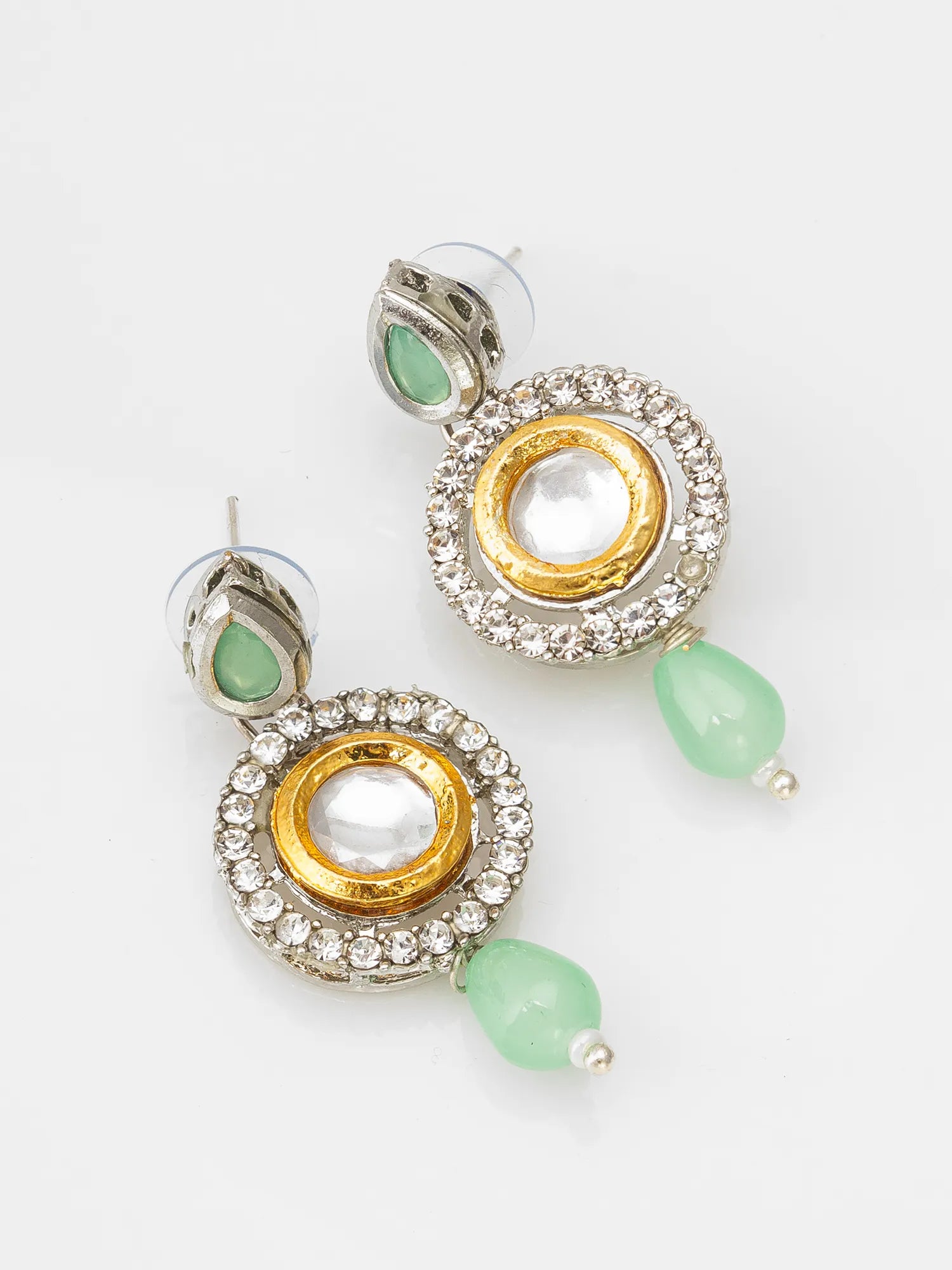 Pair of earrings with gold and silver circular designs and green beads on a white background