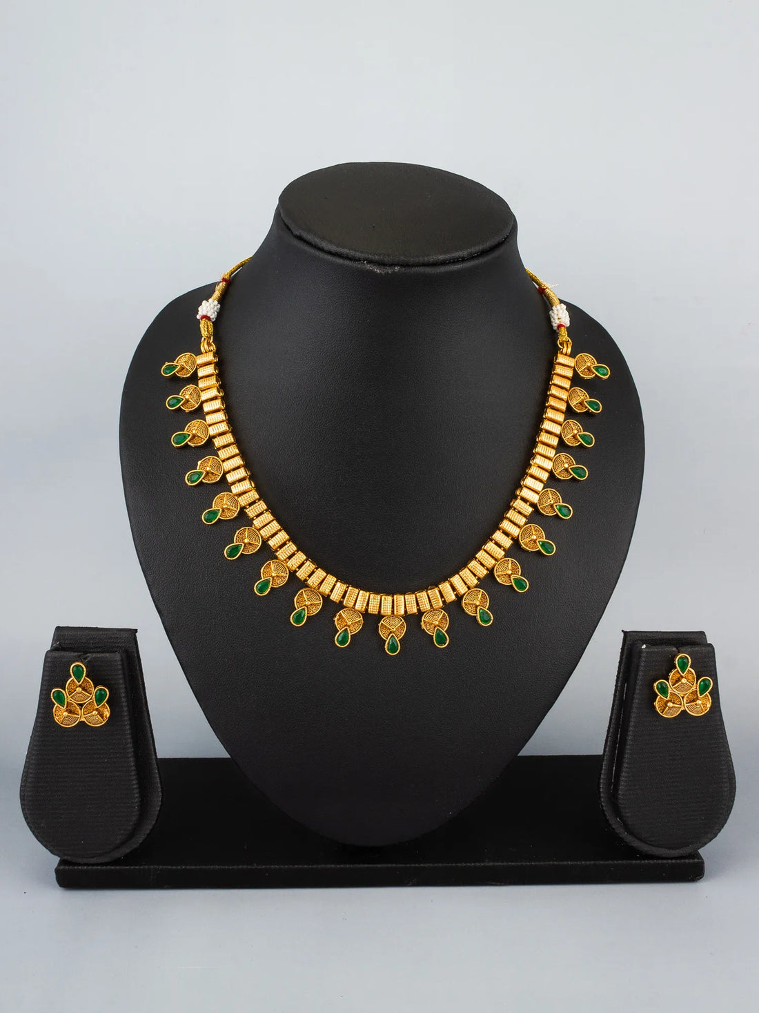Gold necklace and earrings set on a blue background